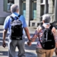 Senior couple with backpacks walking on the street
