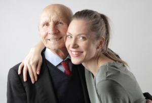 Delighted senior father and adult daughter hugging